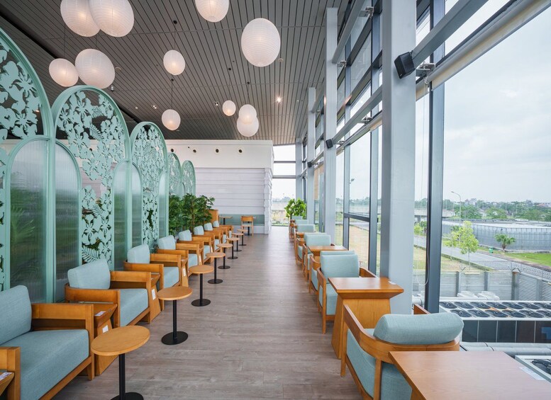 A modern indoor space with wooden furniture, large windows, and decorative paper lanterns. 3