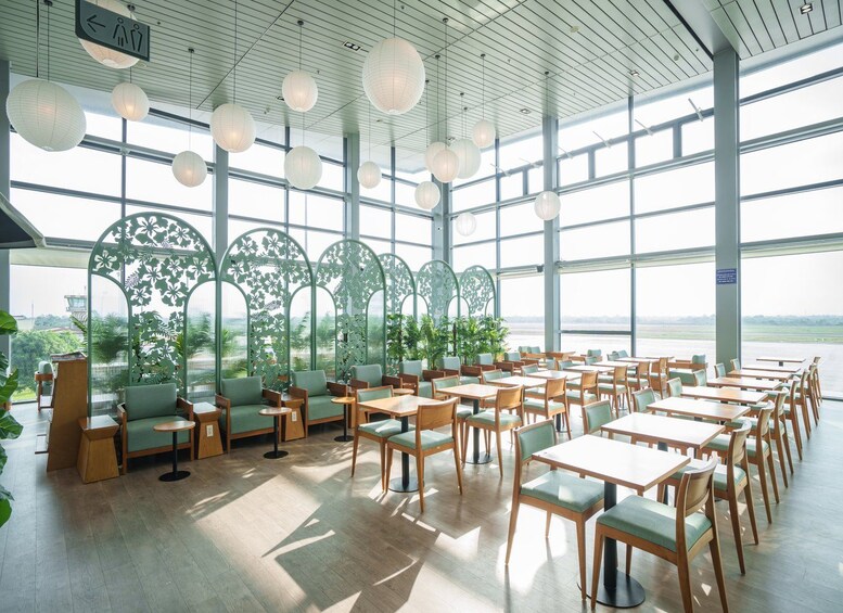 A spacious indoor dining area with tables and chairs, large windows, and decorative paper lanterns. 2