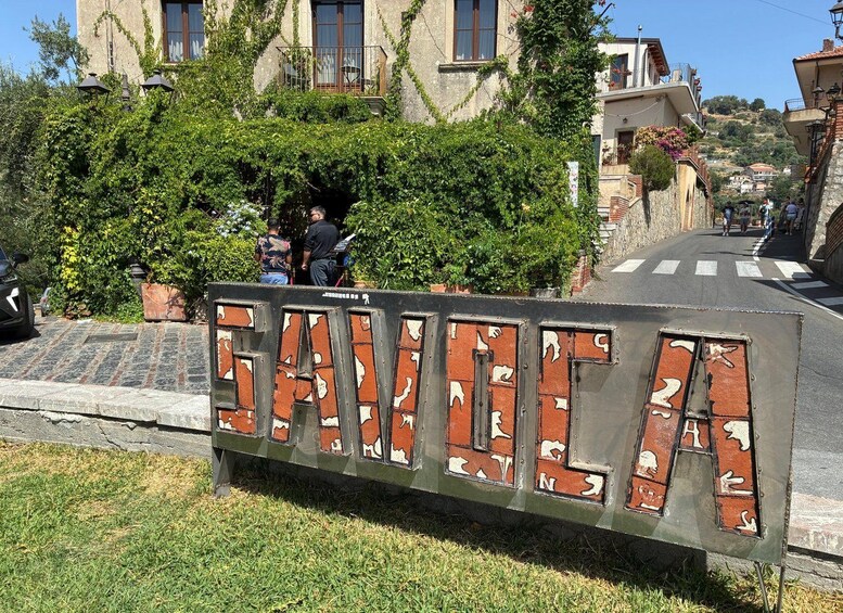 A street sign with the word 'SANDIA' and a road with pedestrians. 4