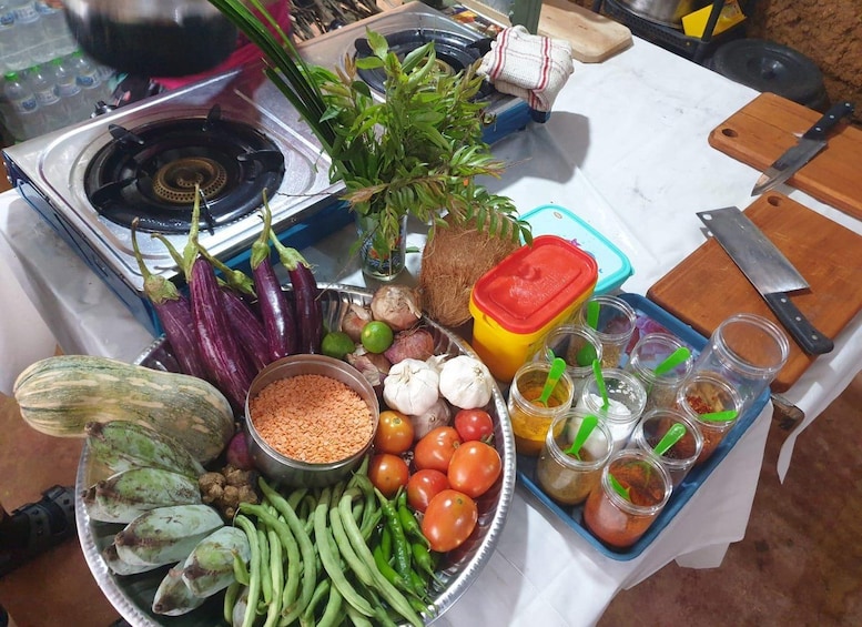 Un plan de travail de cuisine avec divers légumes, une planche à découper, un couteau et une cuisinière à gaz. 4