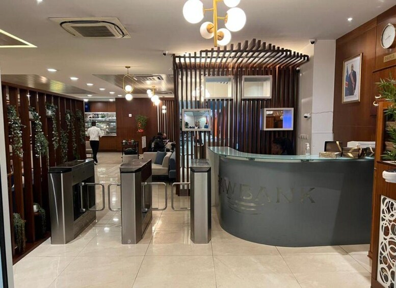 A modern reception area with a curved counter, wooden paneling, and a clock on the wall. 1