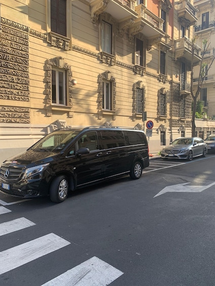 Un SUV Mercedes-Benz negro estacionado en una calle con edificios ornamentales al fondo. 4