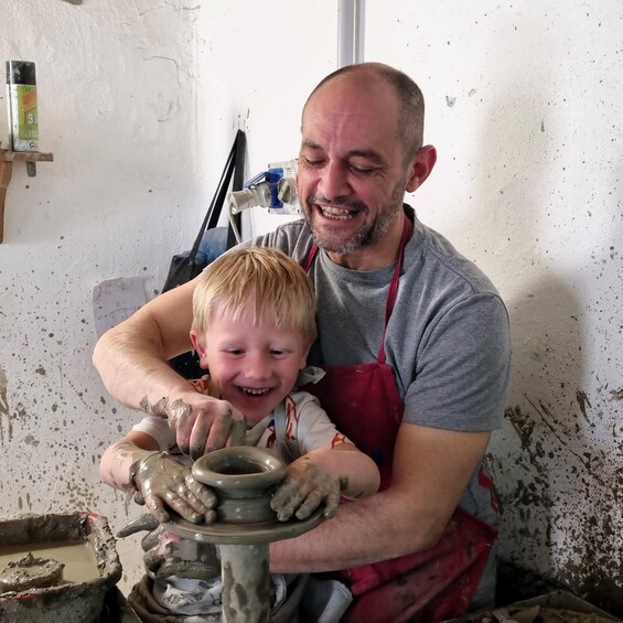 A man and a child engaged in pottery making. 3