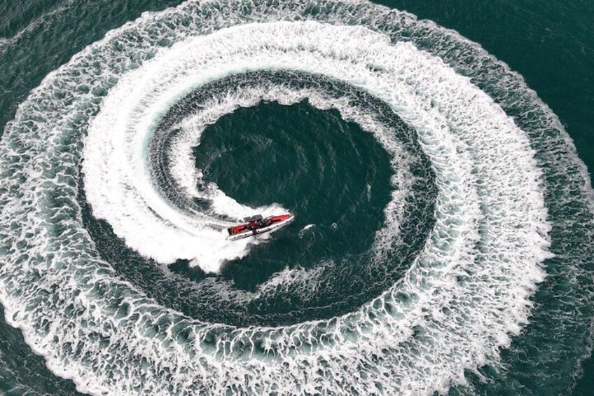 A boat creating a circular wake in the ocean. 1