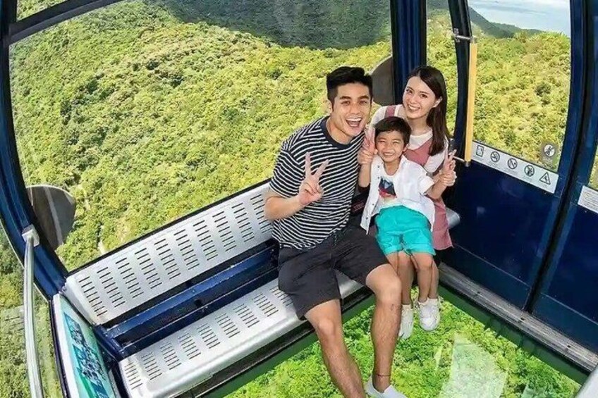 A family on a cable car with a lush green landscape below. 2
