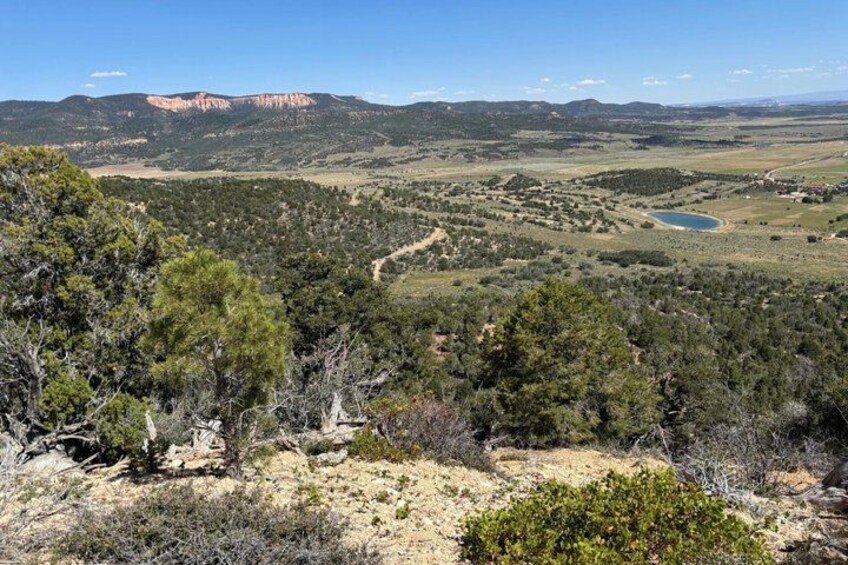 A mountainous landscape with a clear sky, a lake, and a winding road. 4