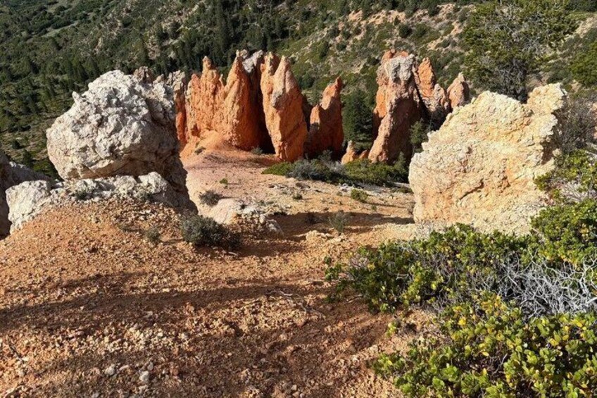 A rocky landscape with prominent red rock formations and sparse vegetation. 5