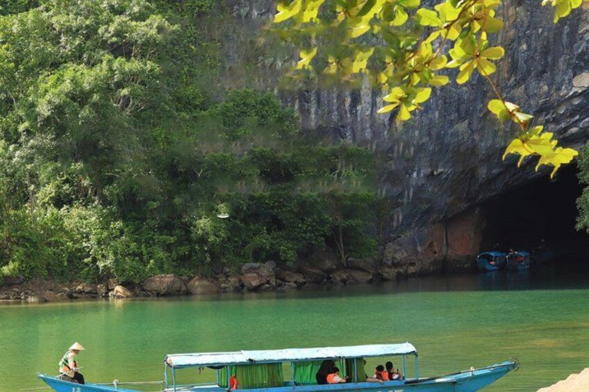 A boat on a river with a cave entrance in the background. 3