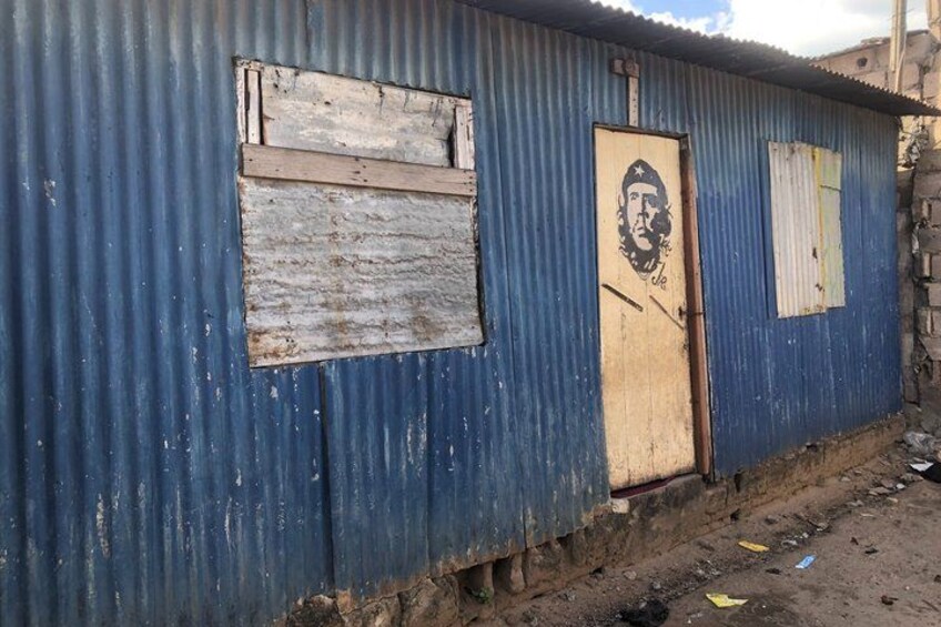 A corrugated metal building with a worn door and a poster. 5