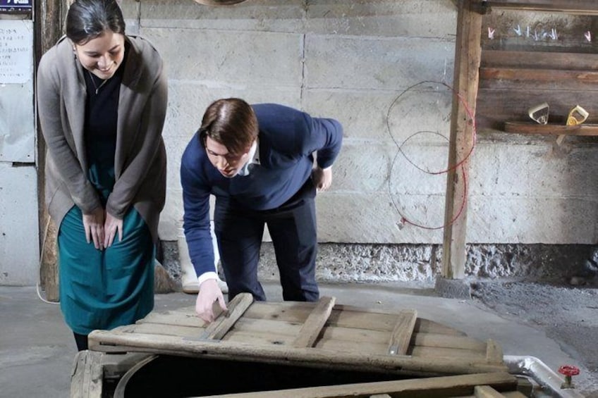 Two people examining a wooden structure in an industrial setting. 3