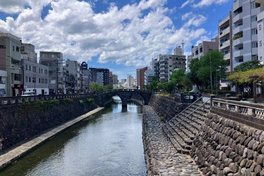 A river with a stone wall on one side and buildings on the other. 5