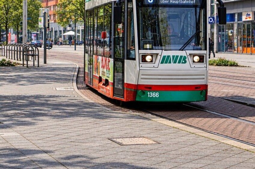 A tram with the number 1366, labeled 'über Hauptbahnhof,' on a city street. 4