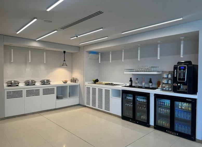 A modern kitchen with white cabinets, a black refrigerator, and a coffee machine. 3