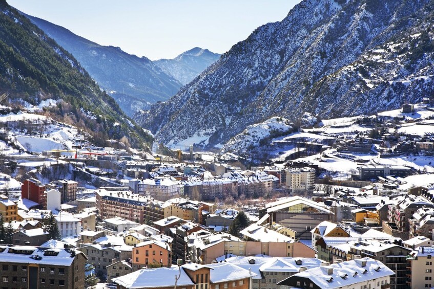 Un pueblo cubierto de nieve anidado en un valle, con montañas al fondo. 5