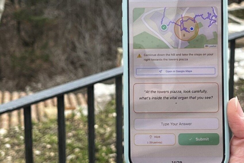 A smartphone displaying a map with a location pin and a hint for a game. 2