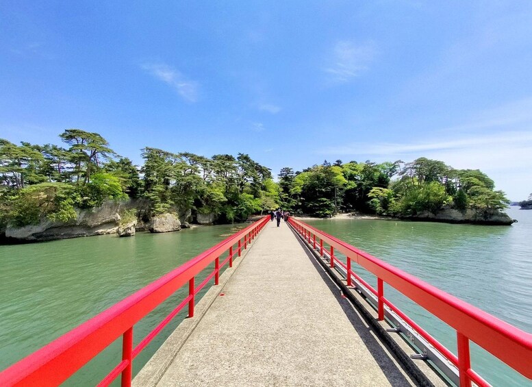 Un puente rojo sobre aguas tranquilas, con árboles a ambos lados. 1