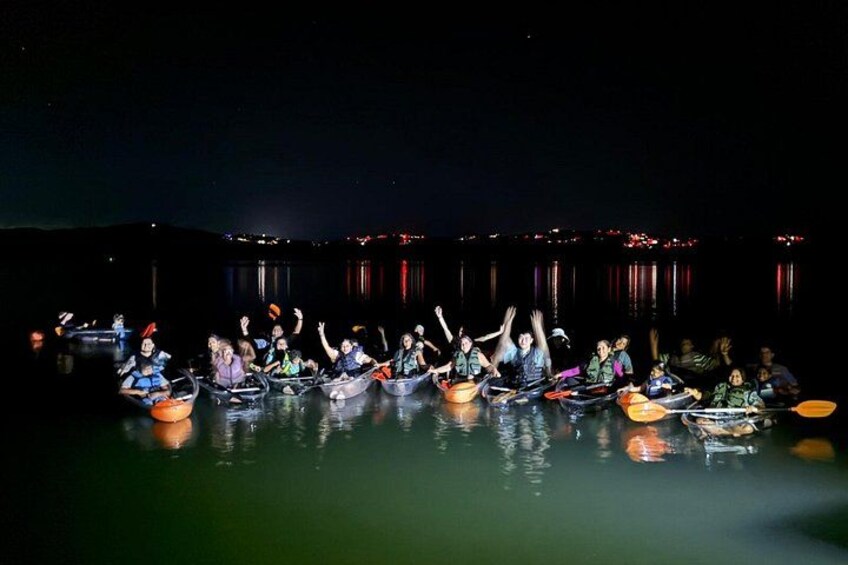 People in canoes on a body of water at night. 2