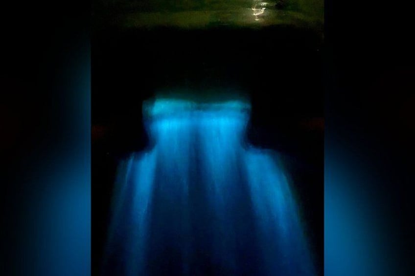 A blurred blue light source in a dark environment. 4