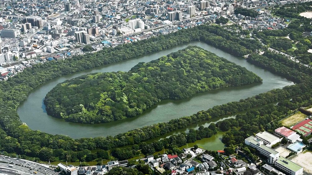 An urban area with a river, dense greenery, and residential buildings. 1