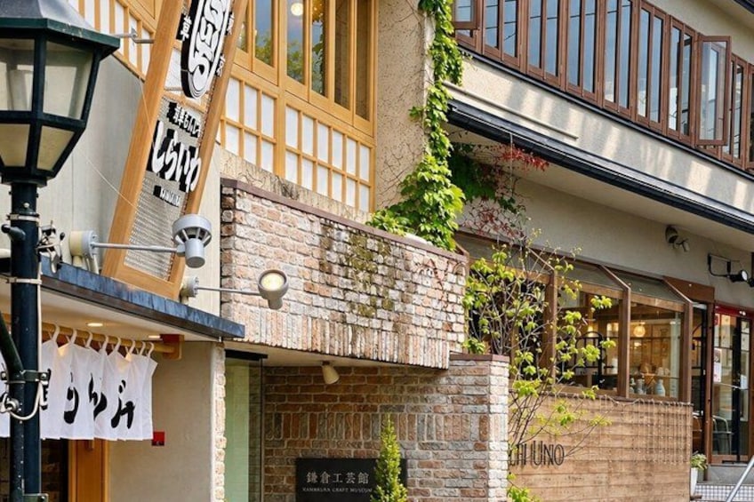 A building with a brick facade, a wooden balcony, and a sign with Japanese characters. 4