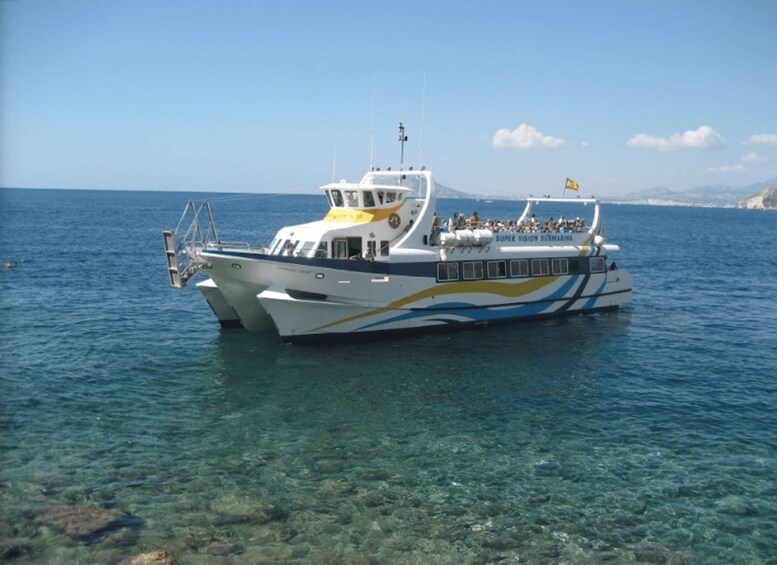 Un ferry blanco y azul llamado 'Super Vision' con pasajeros a bordo, navegando sobre aguas azules y despejadas. 3