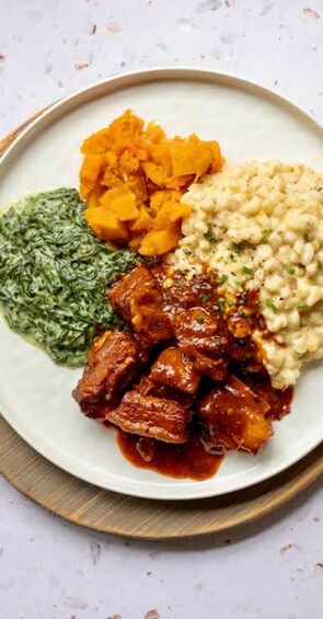 A plate with a meat dish, mashed potatoes, spinach, and sweet potatoes. 3