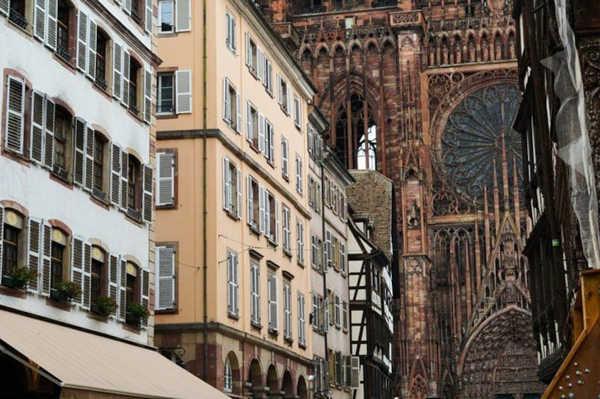 A street with historic buildings, a large cathedral, and a clock tower. 4