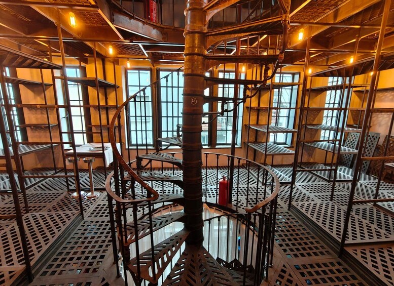 A spiral staircase with metal railings and a patterned floor. 5