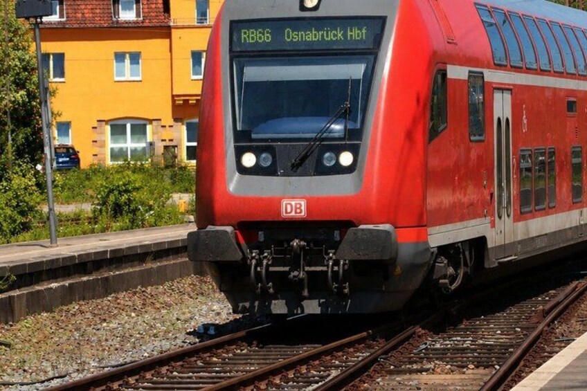 A red train with the destination 'Osnabrück Hbf' on its display. 4