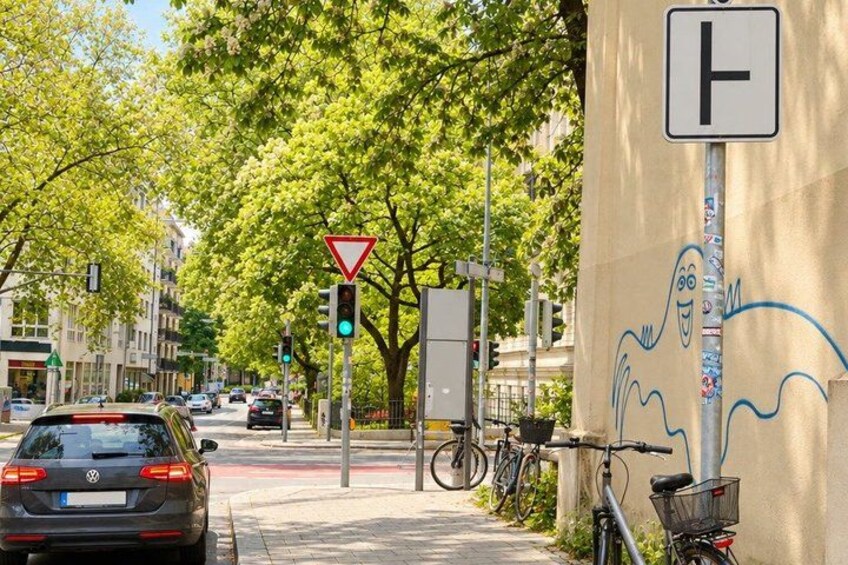 A city street with a traffic light, a yield sign, and a bicycle parked by the curb. 2