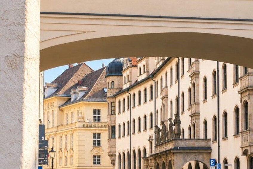 A street with historic buildings, a clear sky, and a pedestrian walkway. 5