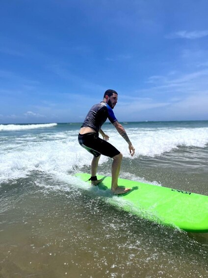 Una persona surfeando en una tabla verde en el océano. 5