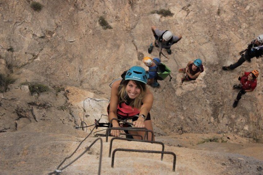 A person climbing a rocky mountain with other climbers. 1