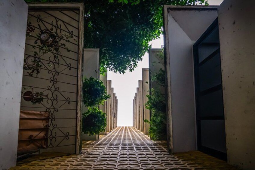 A pathway leading through a gated area with metal gates and decorative elements. 4