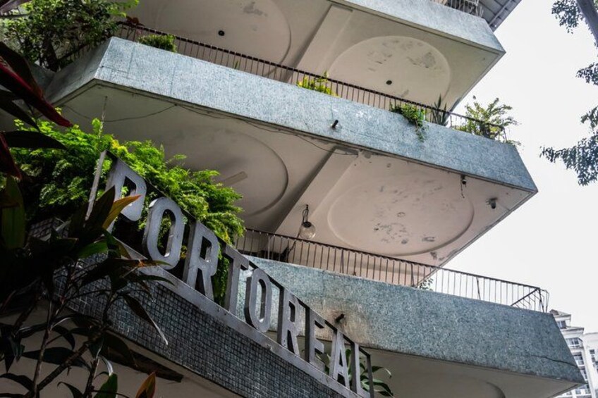 A multi-story building with balconies and a sign that reads 'PORTFORA'. 5
