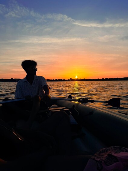 A person sitting on a boat at sunset. 5