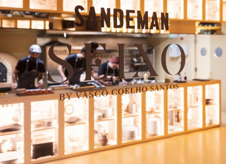 A kitchen with the text 'SANDEMAN SEINO BY VASCO COELHO SANTOS' and a person cooking. 5