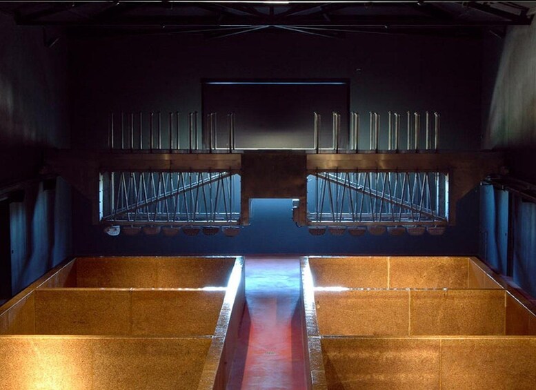 An interior space with a central aisle leading to a stage area, flanked by rows of chairs and a backdrop with vertical lines. 3