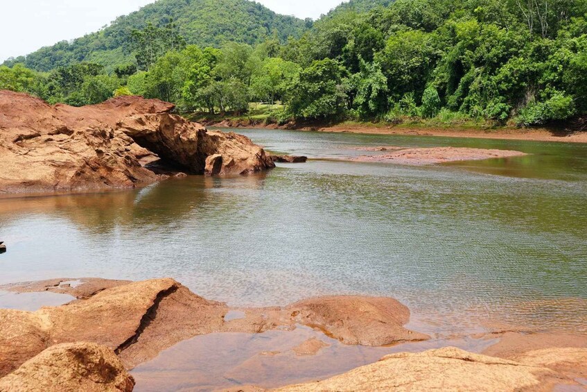 Une rivière aux rives rocheuses, avec une colline boisée en arrière-plan. 4