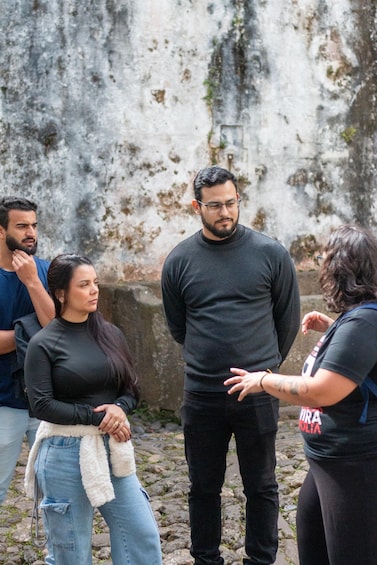 A group of people standing outdoors, engaged in a discussion. 4
