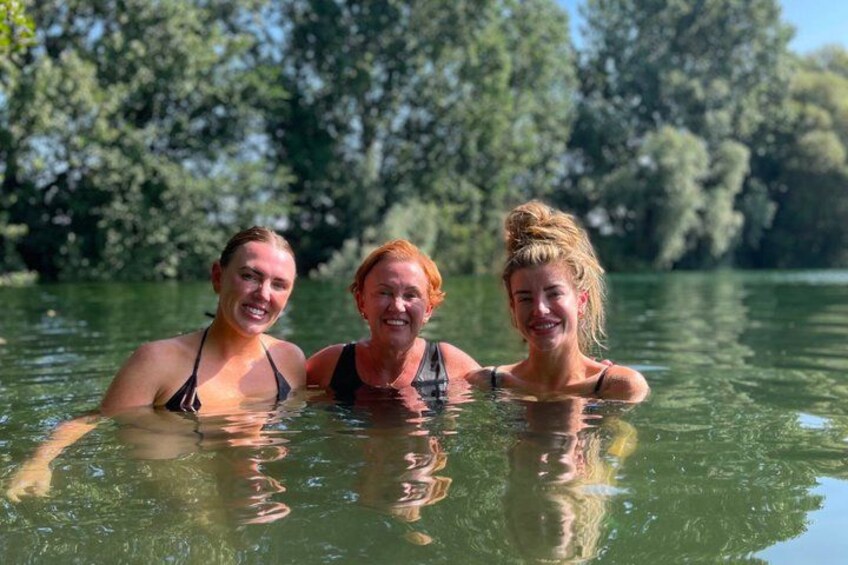 Three people in a body of water surrounded by trees. 3