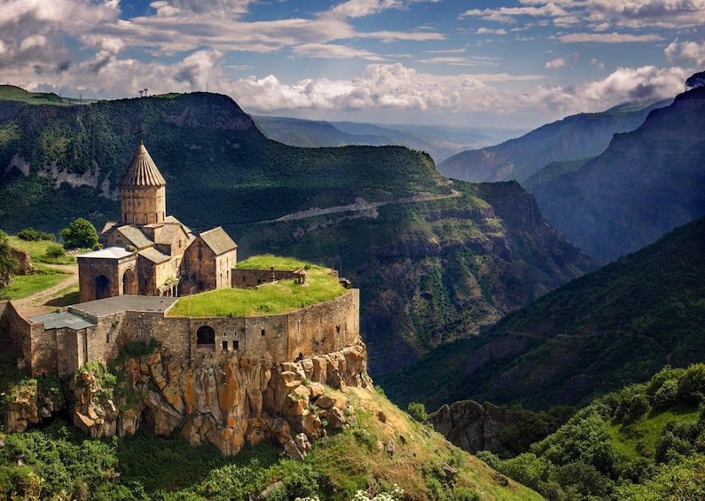 A historic fortress on a cliff overlooking a valley. 1