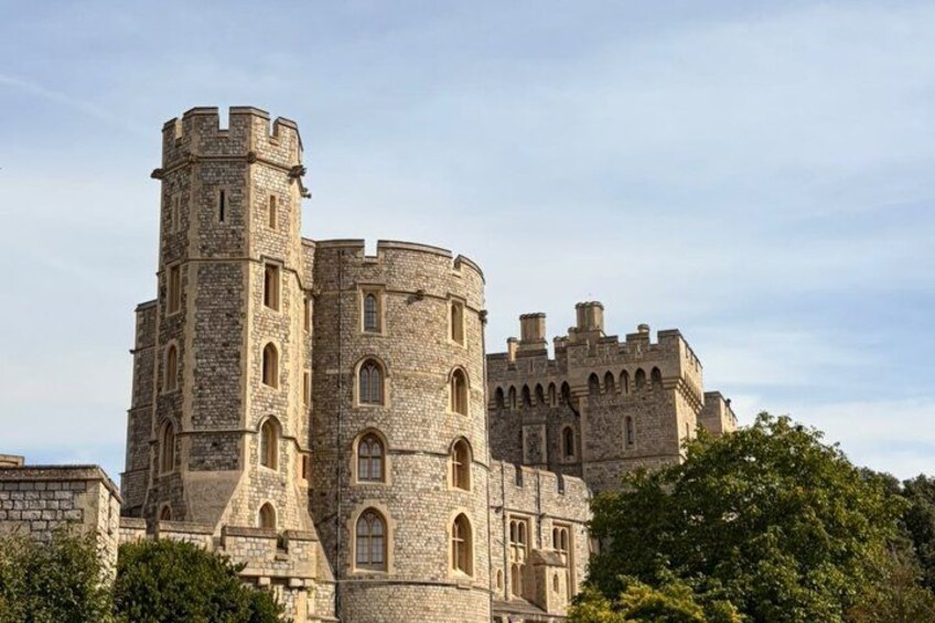A historic stone castle with multiple towers and arched windows. 2