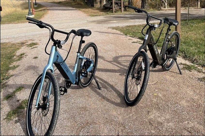 Two bicycles parked on a gravel path. 3