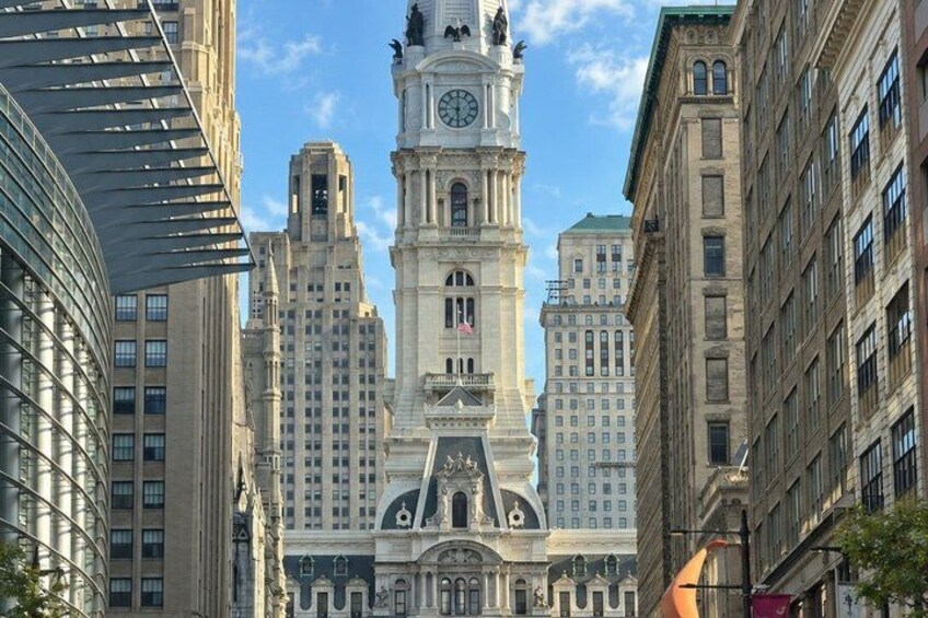 A historic building with a clock tower, surrounded by modern skyscrapers. 2