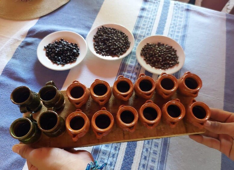 Una bandeja con varias tazas y recipientes de arcilla pequeños que contienen distintos tipos de frijoles. 3