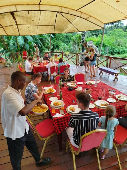 Un área de comedor al aire libre con gente comiendo bajo una marquesina. 1