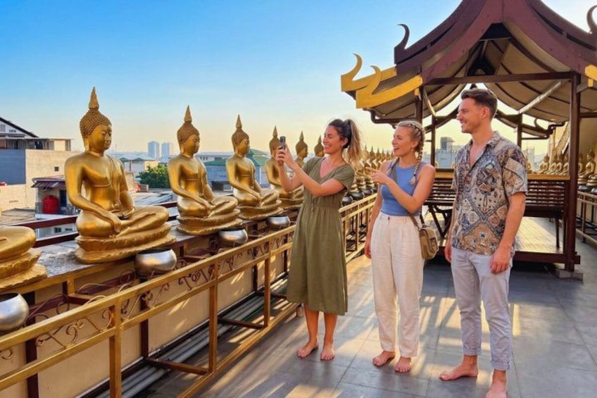 A row of golden Buddha statues on a rooftop with a clear sky in the background. 5