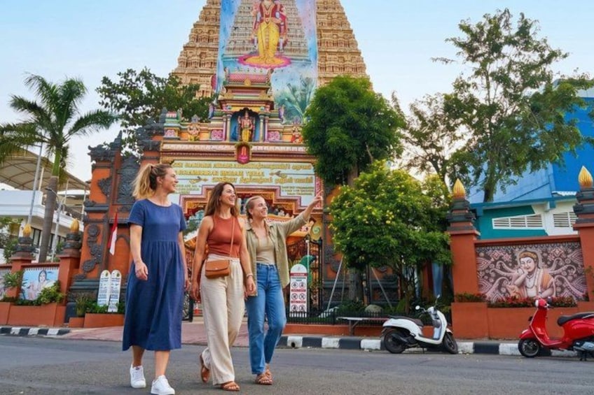 A temple with a large, colorful mural and a tall, ornate tower. 4