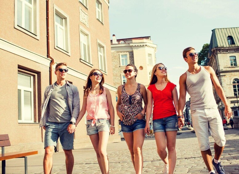 Un grupo de personas caminando por una calle adoquinada en una zona urbana con edificios históricos. 5